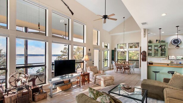 A spacious living room with a large TV, comfortable seating, and a view of the outdoors. - Dream Balcony Lakehouse ~Golf Cart ~Games ~Kayaks (Temple)