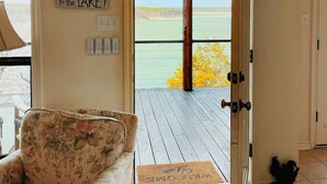 A room with a large window and a door leading to a deck. There is a sign on the wall that reads "Welcome to the Lake!" and a doormat on the deck. - Dream Balcony Lakehouse ~Golf Cart ~Games ~Kayaks (Temple)