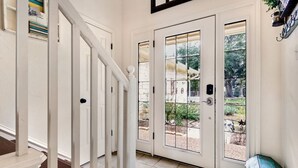 A white interior with a staircase leading to a door with a glass panel. - Dream Balcony Lakehouse ~Golf Cart ~Games ~Kayaks (Temple)