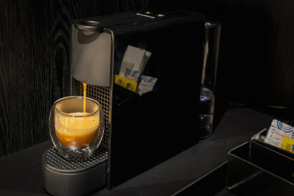 A coffee machine dispensing espresso into a glass cup.