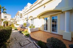 Stunning residential building with balconies and terraces, set amidst beautifully maintained gardens and a charming cobblestone pathway.