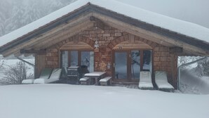 Eine Holzhütte mit überdachter Terrasse, Kamin und Hinweisschild Nummer 13.