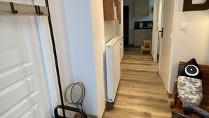 A hallway with a wooden bench, a radiator, a wooden cabinet, and a letter 'B' on the wall. - The bookstore, beachfront house facing Tatihou island, feet in the water ! (Reville)