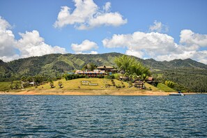 A hotel on a small island with a view of the surrounding hills and a body of water. - Kuma Secret Island - Experience Hotel (Guatapé)