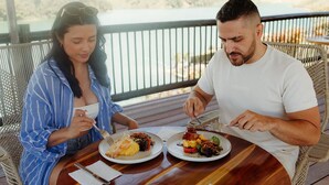Two people dining at an outdoor table with a view of a natural landscape. - Kuma Secret Island - Experience Hotel (Guatapé)