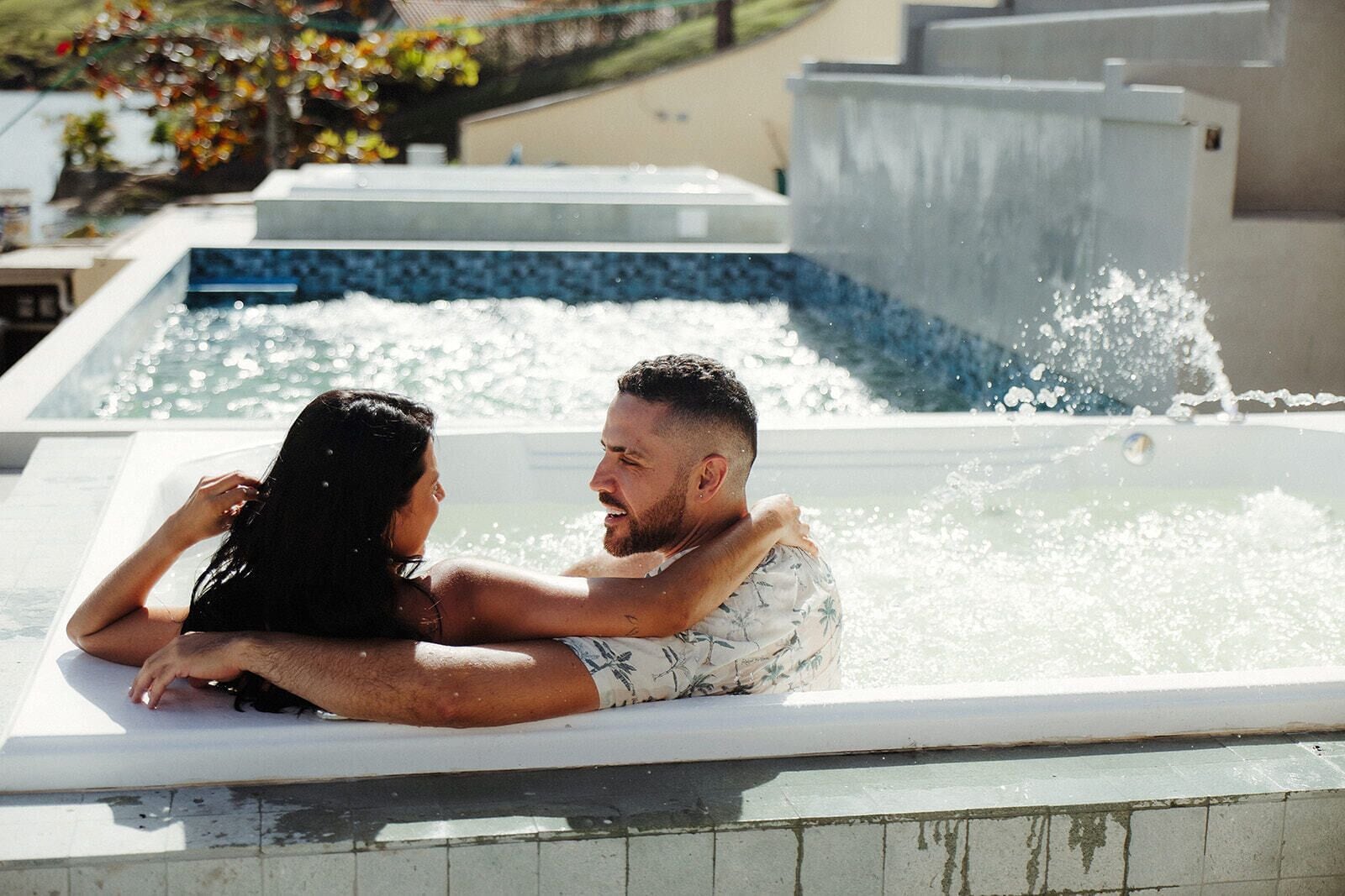 Un couple dans un jacuzzi, l’eau éclaboussant tout autour d’eux.