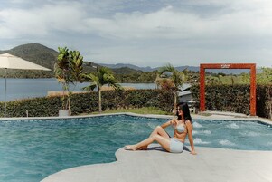Una piscina al aire libre, sillones reclinables de piscina
