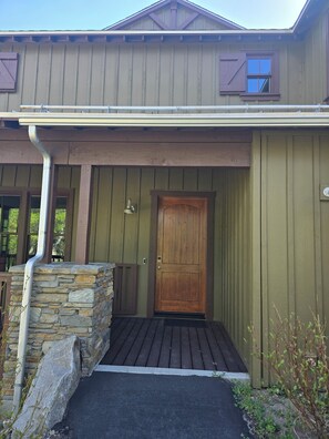 A building with a wooden door, stone steps, and a metal gutter.