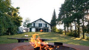 A house with a fire pit in the foreground.