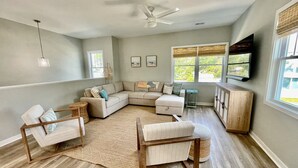 A spacious living room with a sectional sofa, a wooden coffee table, and a ceiling fan. - Potomac Paradise - Water views within short walk to Colonial Beach, VA (Colonial Beach)