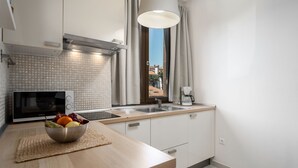 A modern kitchen with a microwave, sink, and a bowl of fruit on the counter.