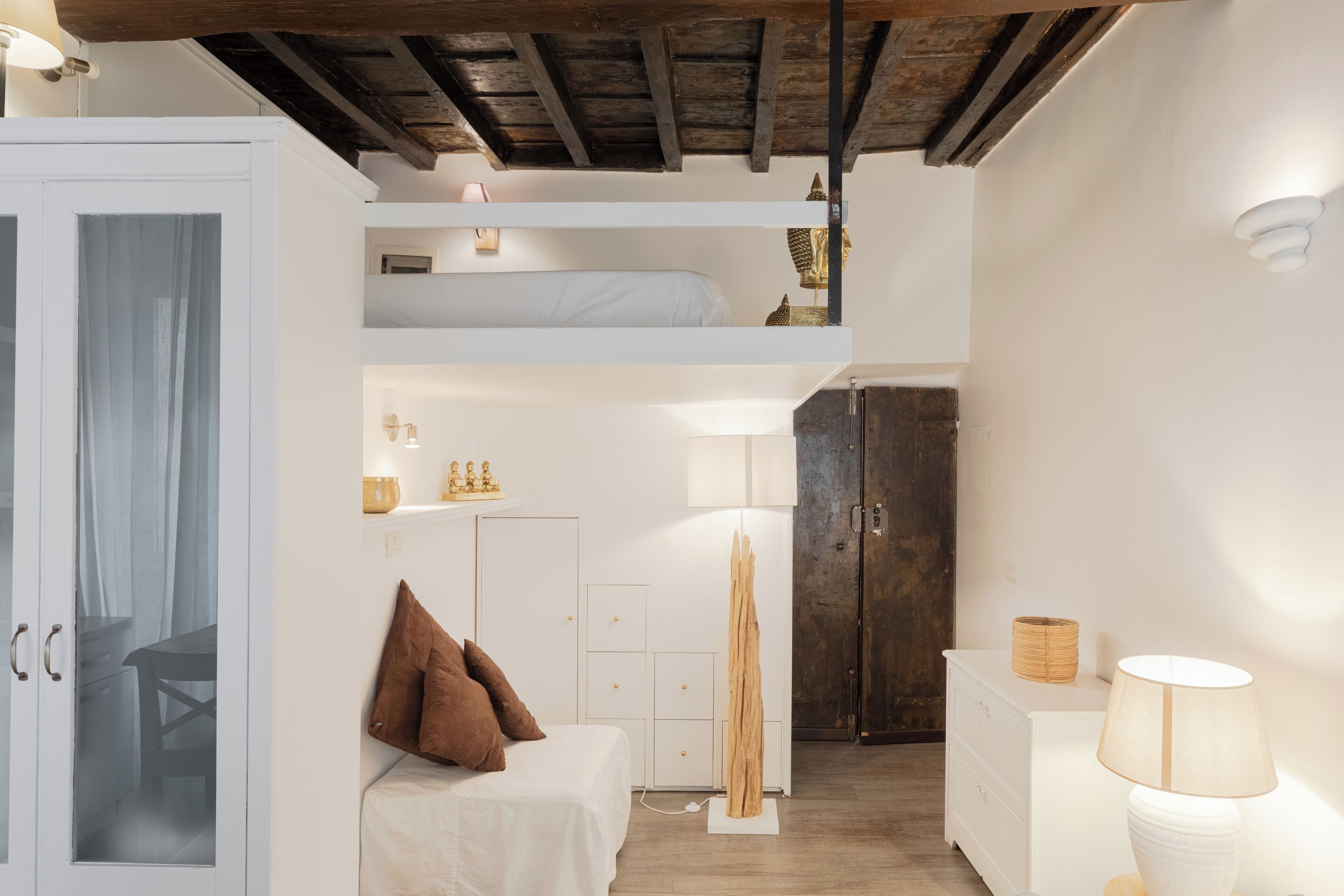 A compact, well-lit room with a bunk bed, a desk, a cabinet, and a wardrobe.