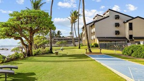 A beachfront hotel with a pool, lounge chairs, and a view of the ocean. - 1 Bedroom Condo :: Oceanfront Resort Kapaa Shore (Kauai)
