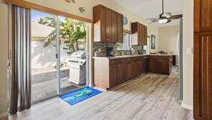 A kitchen with wooden cabinets, a built-in oven, and a view through the sliding glass door.