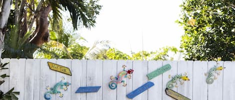 A swimming pool with a white fence decorated with signs and a metal ring.