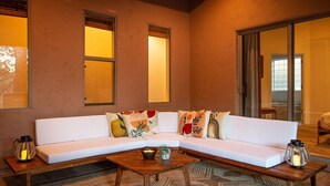 A modern living room with a white sectional sofa, a wooden coffee table, and two wall-mounted sconces. - Enchanted Adobe Hideaway w/Hot Tub & GIANT Chess (Sedona)