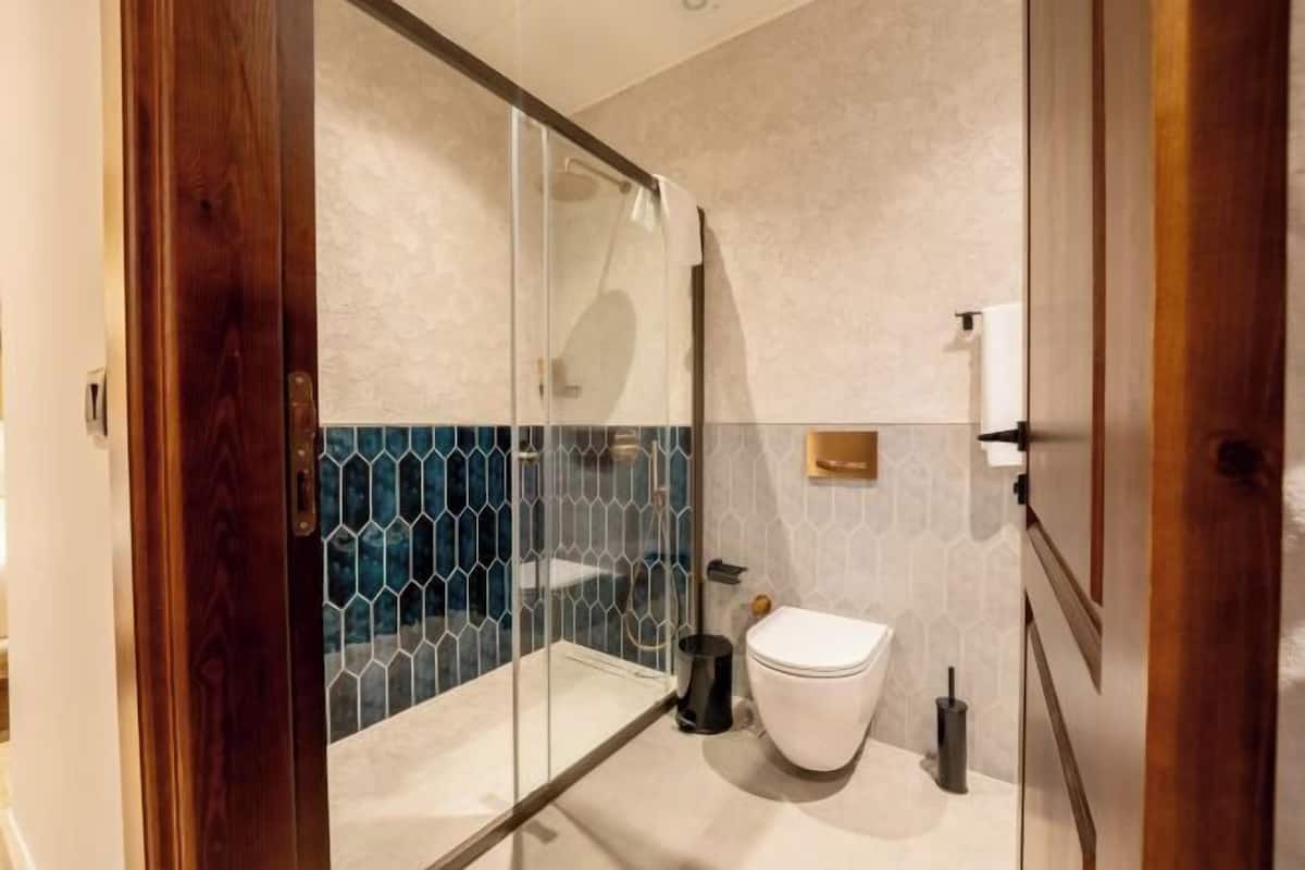 Badkamer | Een douche, een regendouche, een haardroger, badjassen