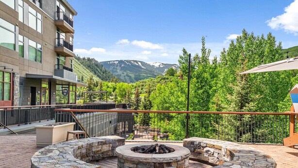 A stone fire pit area with a view of a mountain and forest. - Perfectly Located 2 Minute Walk Lift Downtown Avon (Avon)