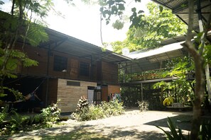 A building with a covered outdoor area, surrounded by vegetation.