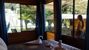 A room with a bed, a window, and a view of the outdoors. - Terrazas del Golfo (Puerto Jiménez)