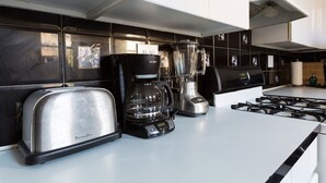 Een moderne keuken met een roestvrijstalen broodrooster, koffiezetapparaat en blender op het aanrecht.