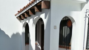 A white building with three arched doorways and a tiled roof. - Villas Tequisquiapan  (Tequisquiapan)