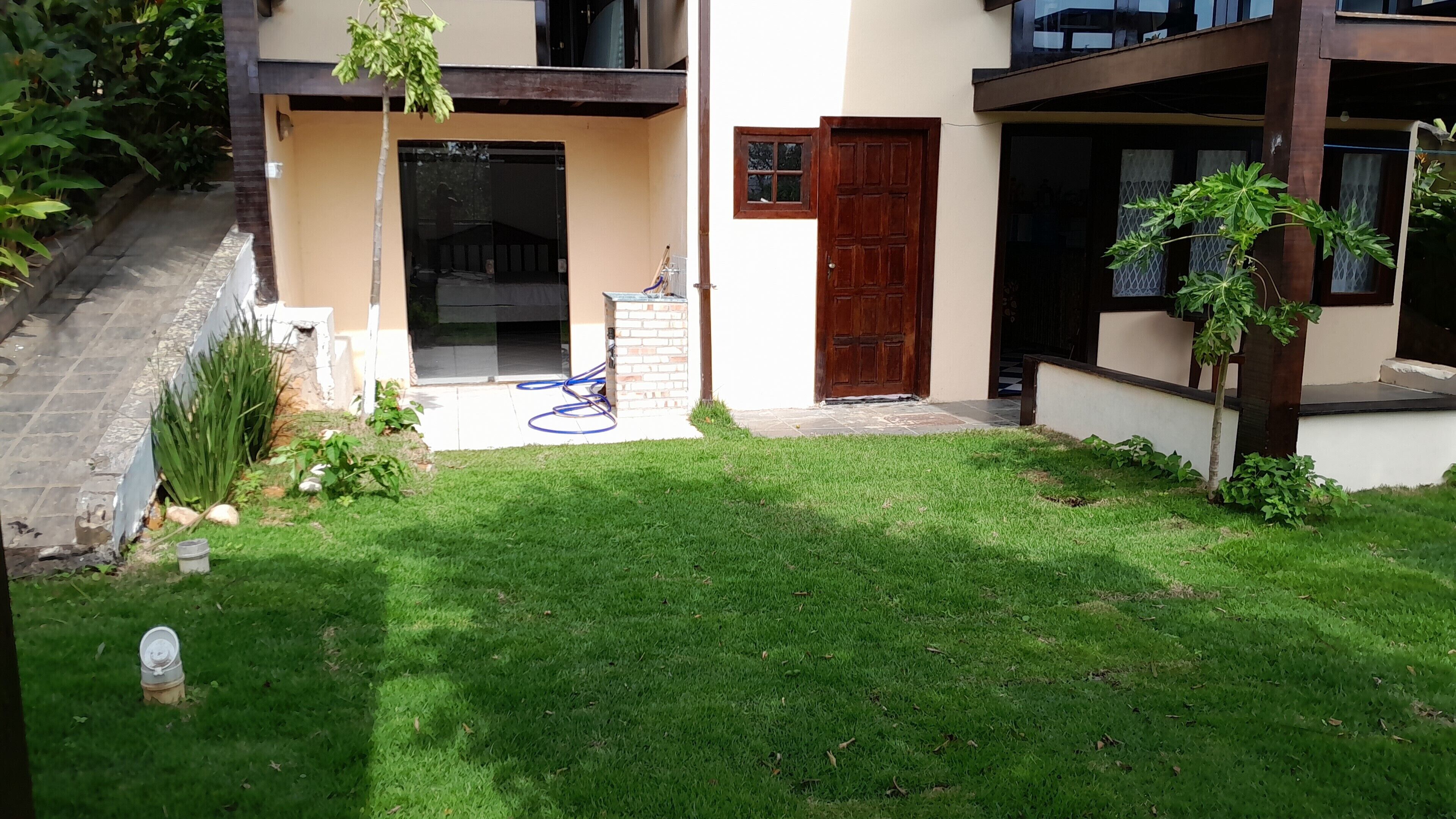 A modern house with a well-maintained lawn, a wooden door, and a small garden area.