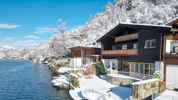 Une propriété au bord du lac, avec des arbres couverts de neige et un quai.