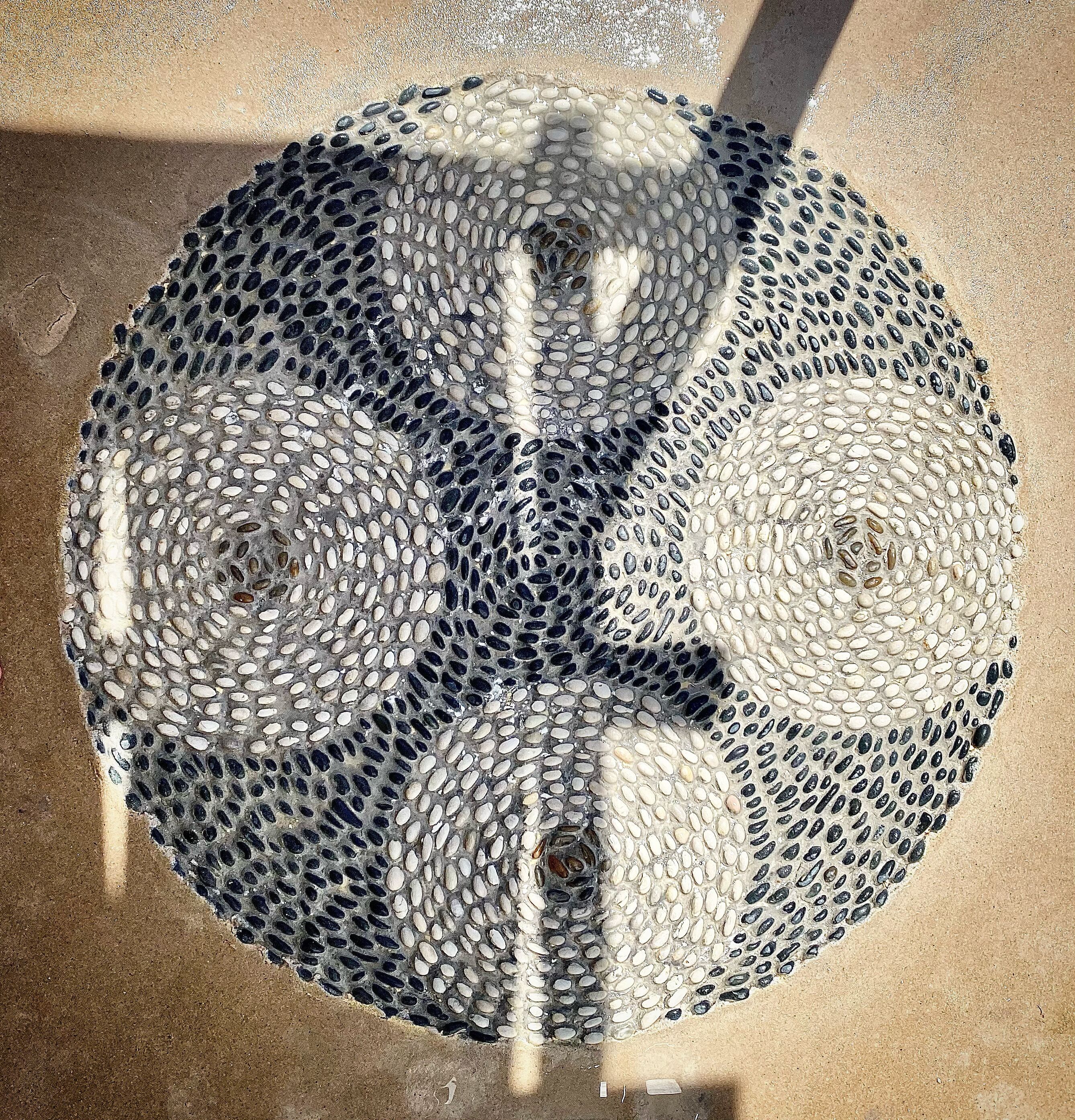 Ein kreisrunder Gegenstand mit strukturierter Oberfläche, möglicherweise ein Dekorationsobjekt oder ein Bauteil.