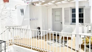 A white building with a covered patio, a door, and a window with shutters. - CABARNUS HOUSE in the HEART of Paroikia, Paros! (Paros)