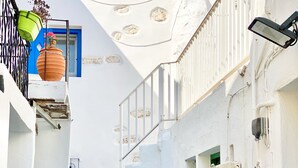A narrow white-washed alley with steps, a green door, and a potted plant. - CABARNUS HOUSE in the HEART of Paroikia, Paros! (Paros)