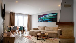 A modern living room with a sofa, coffee table, and dining area. - Résidence Hera Paris Orly Aéroport (Villeneuve-le-Roi)