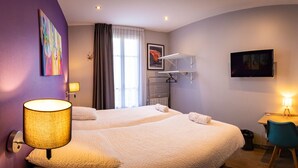 A hotel room with two beds, a desk, a chair, a TV, a painting, and a lamp. - Résidence Hera Paris Orly Aéroport (Villeneuve-le-Roi)