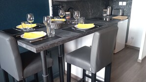 Una cucina moderna con isola centrale, mobili scuri e schienale in marmo.