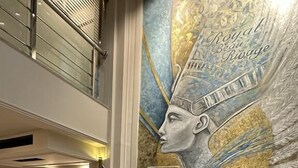 A modern lobby with a mural, a curved orange sofa, and a marble floor. - Nile Cruise Luxor&Aswon IncludingTours (Luxor)