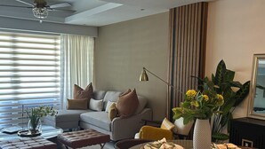 A modern living room with a dining area, featuring a chandelier, a sofa set, and a dining table set for four. - A Luxe family stay that is 5 minutes from the beach and a step away to the pool. (Punta Cana)