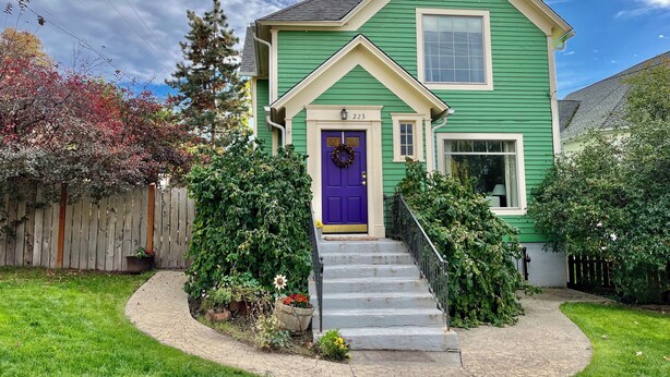 A green house with a purple door, number 223, and a front porch with steps. - Downtown Historic Home / Full Kitchen / W/D / Coffee, Tea, Cold Drinks, Snacks (Moscow)