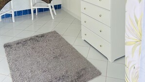 A modern kitchen with white cabinets, blue tiles, and a flat-screen TV mounted on the wall. - Nice and cozy ocean front studio with private terrace. Short walk to beaches. (Beacon Hill)