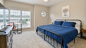 A bedroom with a bed, desk, chair, and a window with blinds. - Tiger's Den on Dean In Auburn, 3BR/2.5BA 3 Miles from Jordan-Hare! (Auburn)