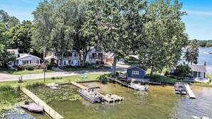 A lakeside property with a dock, boats, and houses. - Escape to Hutchins Lake (Fennville)