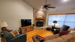 A living room with a fireplace, a television, and a sofa.