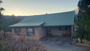 A two-story building with a metal roof, a front porch, and a driveway leading to the entrance.