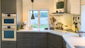 A modern kitchen with built-in appliances, a large window, and a view of the outdoors. - Nice home in Hjältevad with sauna (Hjältevad)