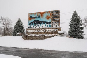 A sign for MASSANUTTEN FOUR SEASON RESORT with amenities like indoor waterpark, golf courses, day spa, dining, and snow sports.