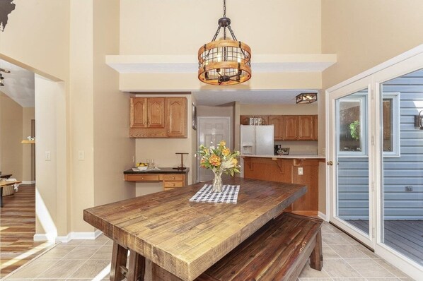 A spacious kitchen with wooden cabinets, a central island, and a hanging light fixture.