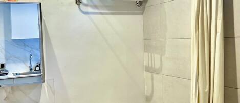 A modern bathroom with a white sink, toilet, and shower curtain.