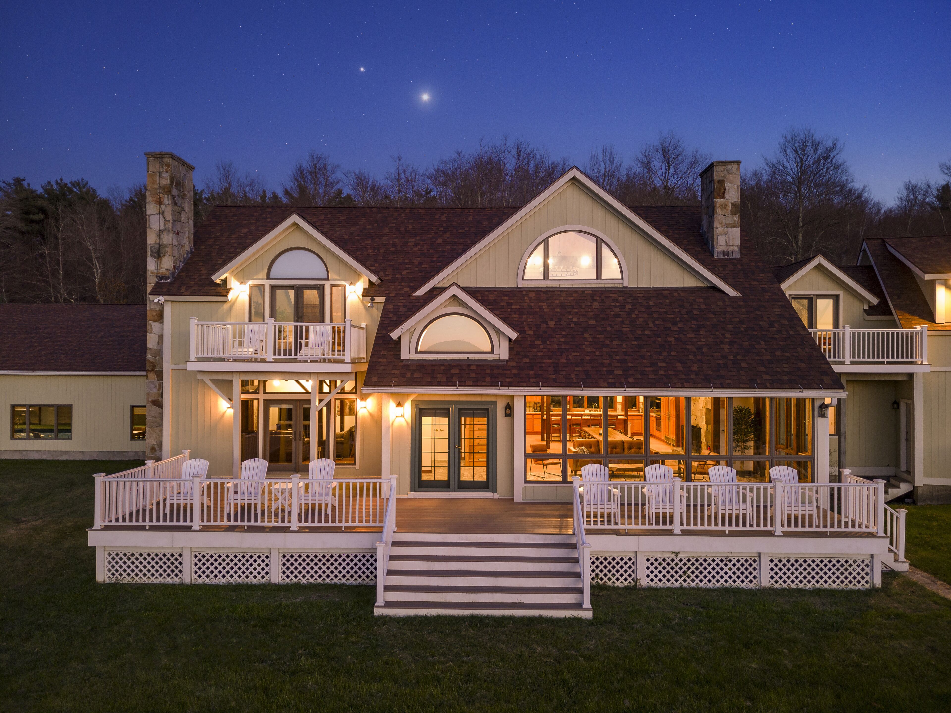 A two-story house with a balcony, a dining area, and a staircase leading to the entrance.