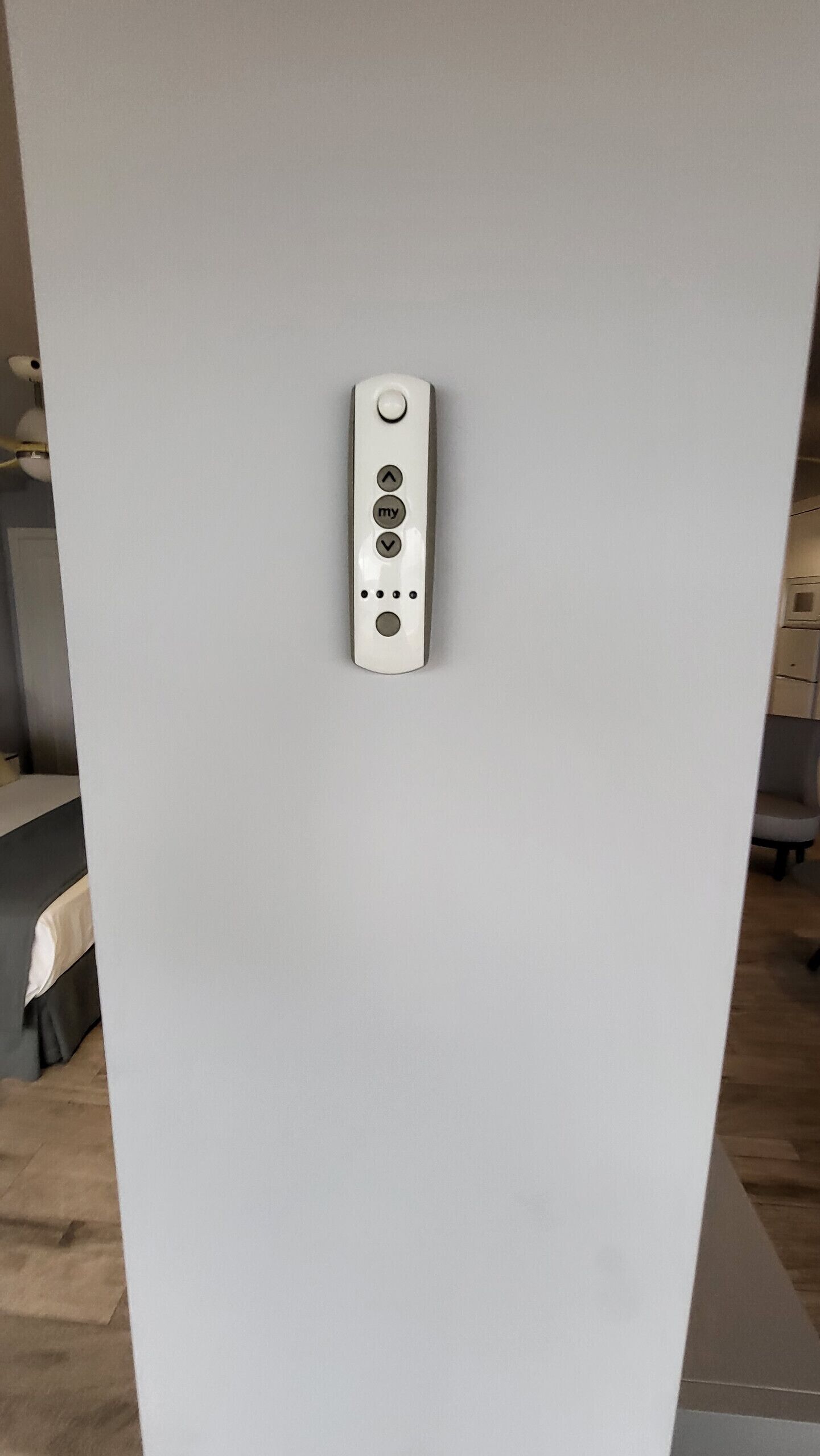 En vit vägg med ett rektangulärt föremål som ser ut att vara en kontrollpanel eller ett gränssnitt, troligen för ett rums elektroniska system.
