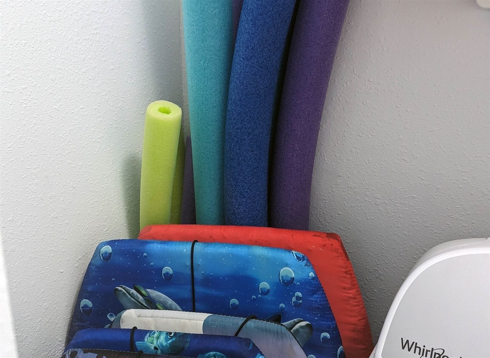 Un juego de felpudos de colores y una almohada azul con un diseño de ballena.