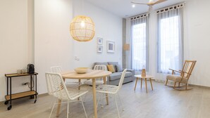 A modern living room with a round table, white chairs, a sofa, a rocking chair, and a ceiling fan. - Ca Celieta Beach I WiFi+ Air Condition (Valencia)